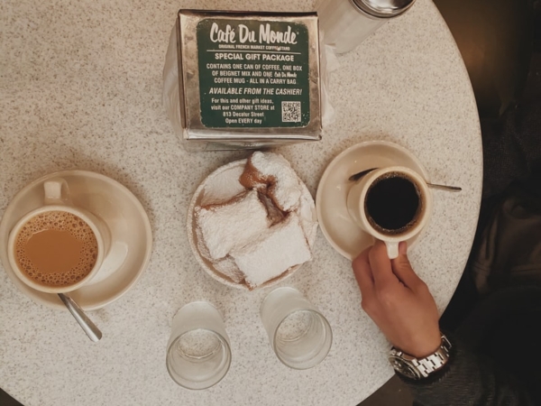 Two people enjoying coffee and beignets